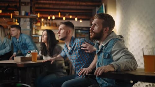 Excited Friends Watch Sports Game in Bar