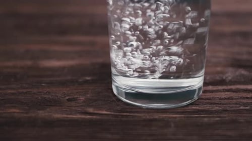 Man Pours Water Into a Glass and Puts Down Pills