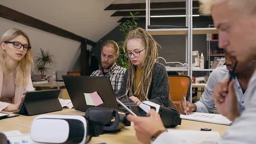 Group of Men and Women Sitting at the Office Table and Working Together Under Business Project
