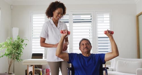 Woman Helps Senior Man Lift Weights in Wheelchair