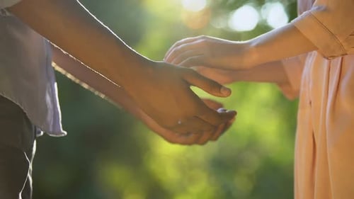 Close Up of Mixed-Race Lovers Holding Hands in Park, Romantic Relationship