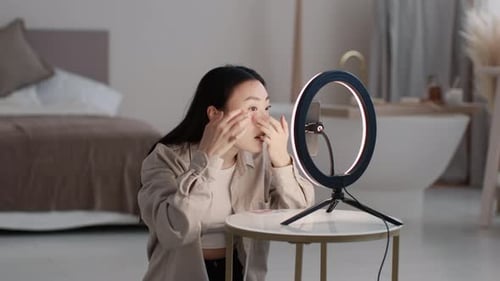 Young Popular Korean Lady Beauty Blogger Recording Video Review About Innovative Cosmetics Applying
