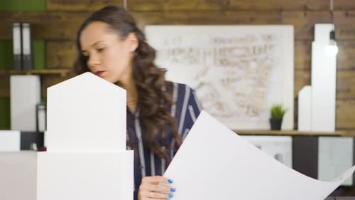 Caucasian Female Architect in Front of Building Models