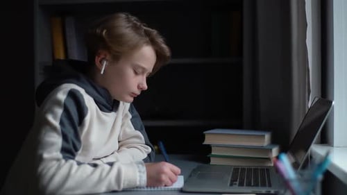 Teen Studies at Laptop and Takes Notes