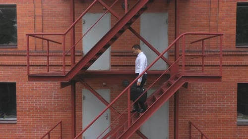 Businessman Going Down the Stairs of a Business Centre Building
