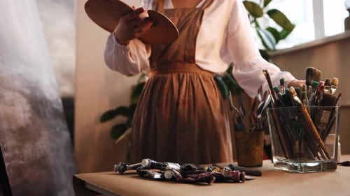 Art Studio Young Woman Artist Working with a Painting