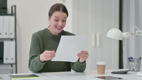 Excited Woman Reads Document in the Office