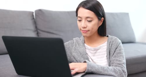 Woman Typing on Laptop in Living Room