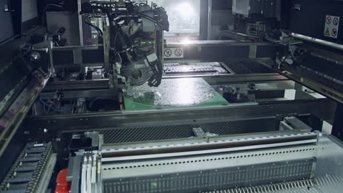 Close up of SMT Machine placing components on a circuit board