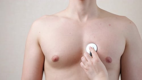 Doctor Listens To Young Adult Male Chest