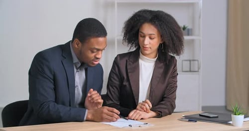 Two Afro American Business Partners Couple of Ethnic People Sitting at Table Reading Document Woman