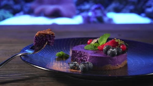 Piece of Purple Cheesecake on Fork Near Aquarium.