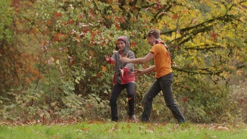 Boys Throwing Leaves in the Autumn Park