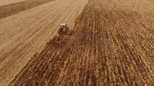 Top View of Tractor Plowing Field After Harvest