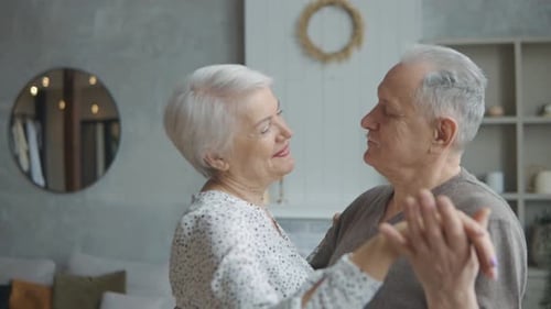 Affectionate Senior Couple Dancing Together in Living Room