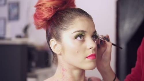 Vue rapprochée de la maquilleuse qui fabrique des modèles de maquillage pour les yeux avec de faux cils