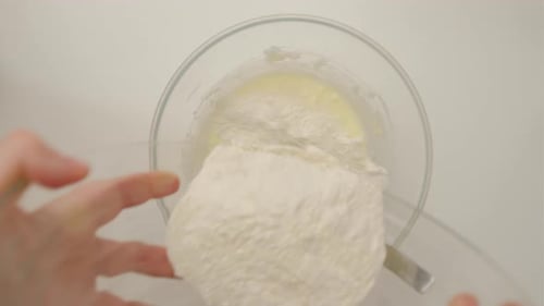 Top view of woman hands making dough for homemade cookies on the white table