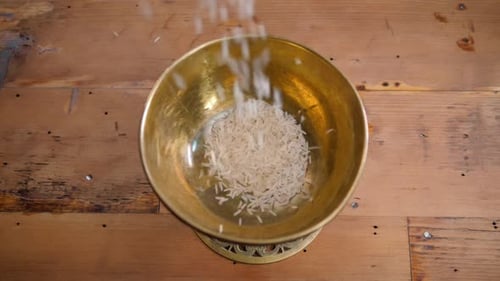 Dry Basmati Rice Fall in Wood Gold Metal Bowl on Table From Hands Woman Slow Motion Close Up Macro