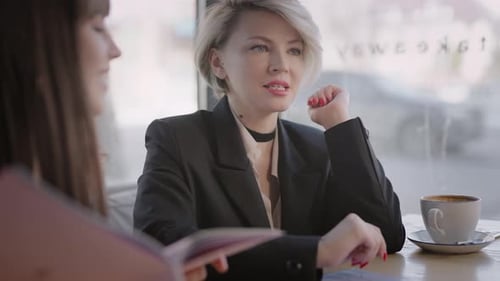 Una joven atractiva en un café rodeada de sus novias