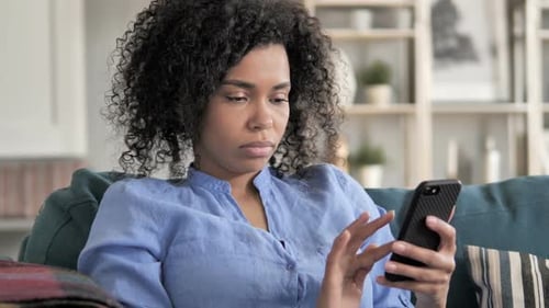 Woman Uses Smartphone on Couch at Home