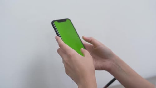 Woman Typing On The Mobile Phone With A Green Screen