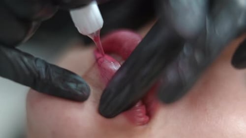 Closeup Tattooing Lower Lip with Microblading Pen in Beauty Salon