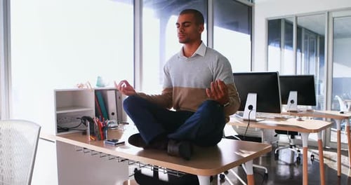 Male executive doing yoga in office 4k