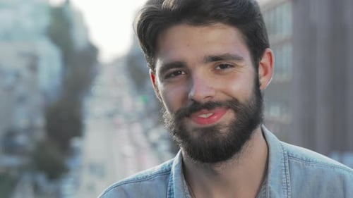 Smiling Bearded Young Man in Urban Setting