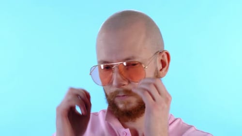 Bald Man Puts On Aviator Sunglasses and Smiles