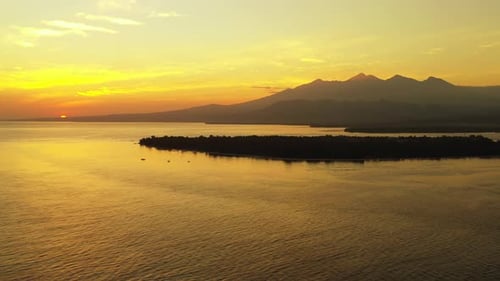 fantastic colors of tropical sunset. Mountain island on the horizon
