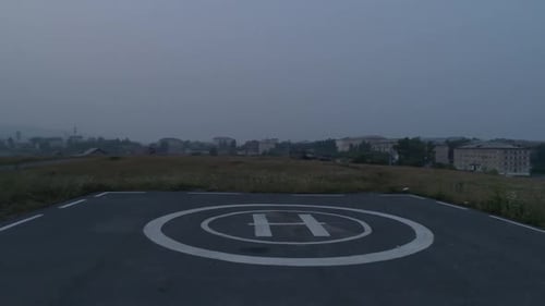Drohnen-Luftaufnahmen eines asphaltierten Hubschrauberlandeplatzes für Hubschrauber im Feld