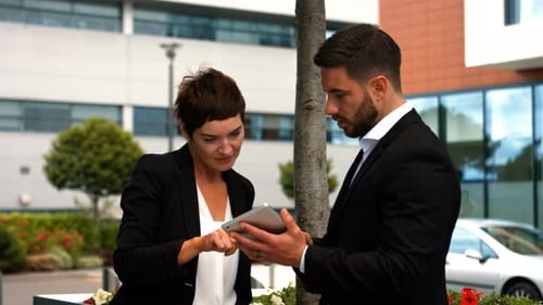 Business Professionals Discuss Tablet Data Outdoors