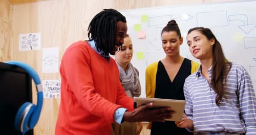 Führungskräfte diskutieren im Büro über digitales Tablet