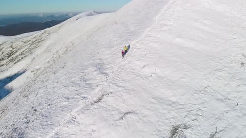 Hikers Traverse Snowy Mountain Ridge in Winter