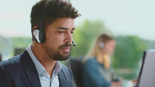 Ernsthafter Mann gemischter Abstammung mit Headset