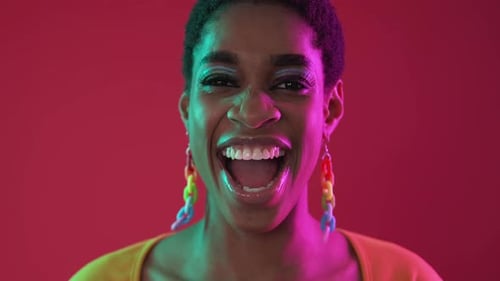 Glamorous Woman Smiling with Colorful Makeup and Earrings