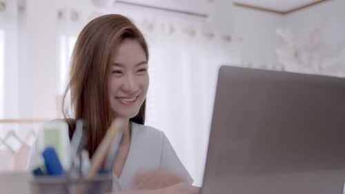 Woman Video Chats on Laptop Computer at Home