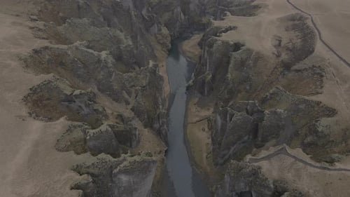 Aerial top-down forward over magnificent and massive Fjadrargljufur canyon, Iceland