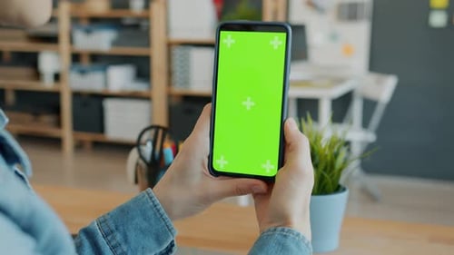 Close-up of Female Hands Holding Chroma Key Green Screen Smartphone in Office