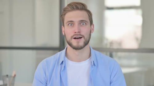 Young Man Reacting with Surprise and Happiness