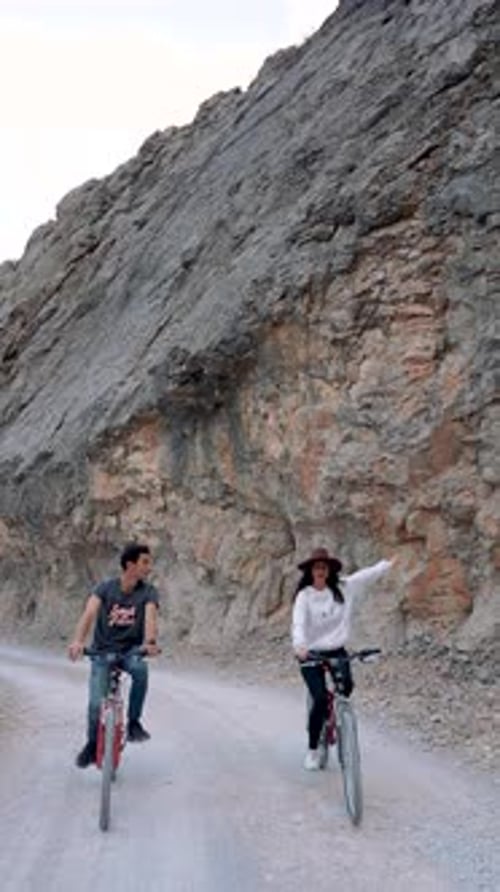 Young Adults Bike on Rocky Road, Natural Setting