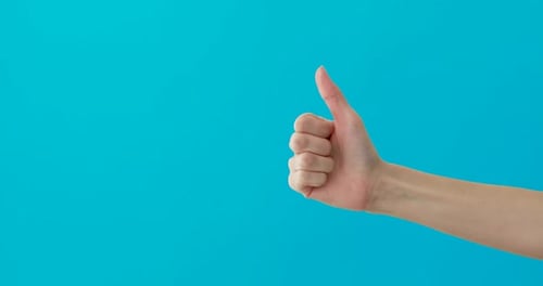 Hand Making a Thumbs-Up Gesture on Blue Background