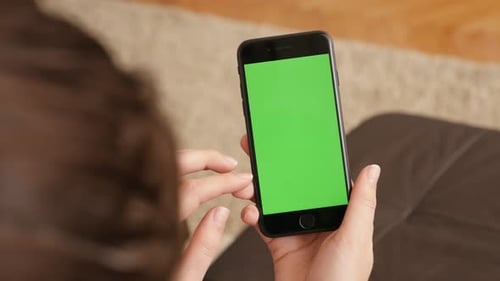 Female brunette at home using green screen display smart phone 4K 2160p 30fps UHD footage - Woman wi