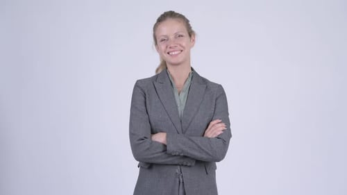 Jeune femme d'affaires blonde heureuse souriante aux bras croisés
