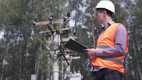 Elektriker überprüfen die Stromleitung, das Ergebnis ist in ein Notizbuch geschrieben.