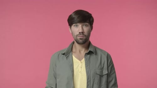 Man Smiling at the Camera Against Pink Backdrop