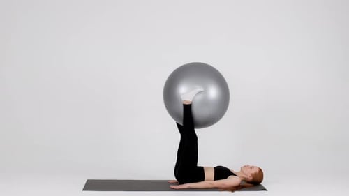 Sportliches Training junger Frauen mit Fitball auf weißem Hintergrund im Studio