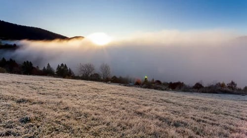 Sun Rises From Behind Mountain Top Fog Moves and Rises Up at Dawn on Summer Morning in Mountains