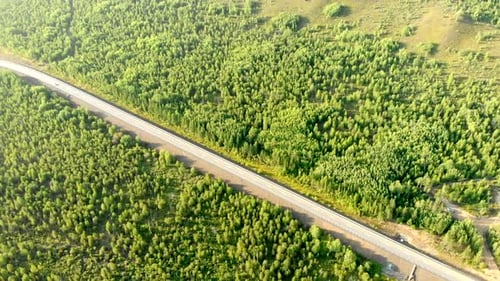 Aerial Flying Over a Rural Road with Two Cars Driving Opposite Each Other