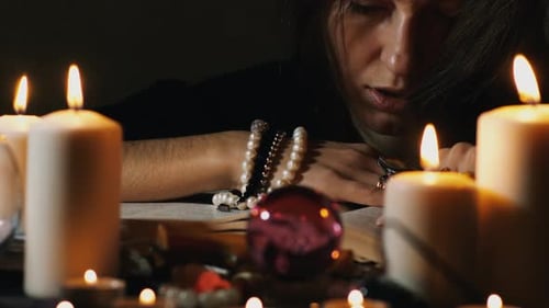 Woman Reads a Book by Candlelight
